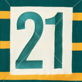 Close up of the number 21 within a cream box on the back of the WOA knit rugby polo.