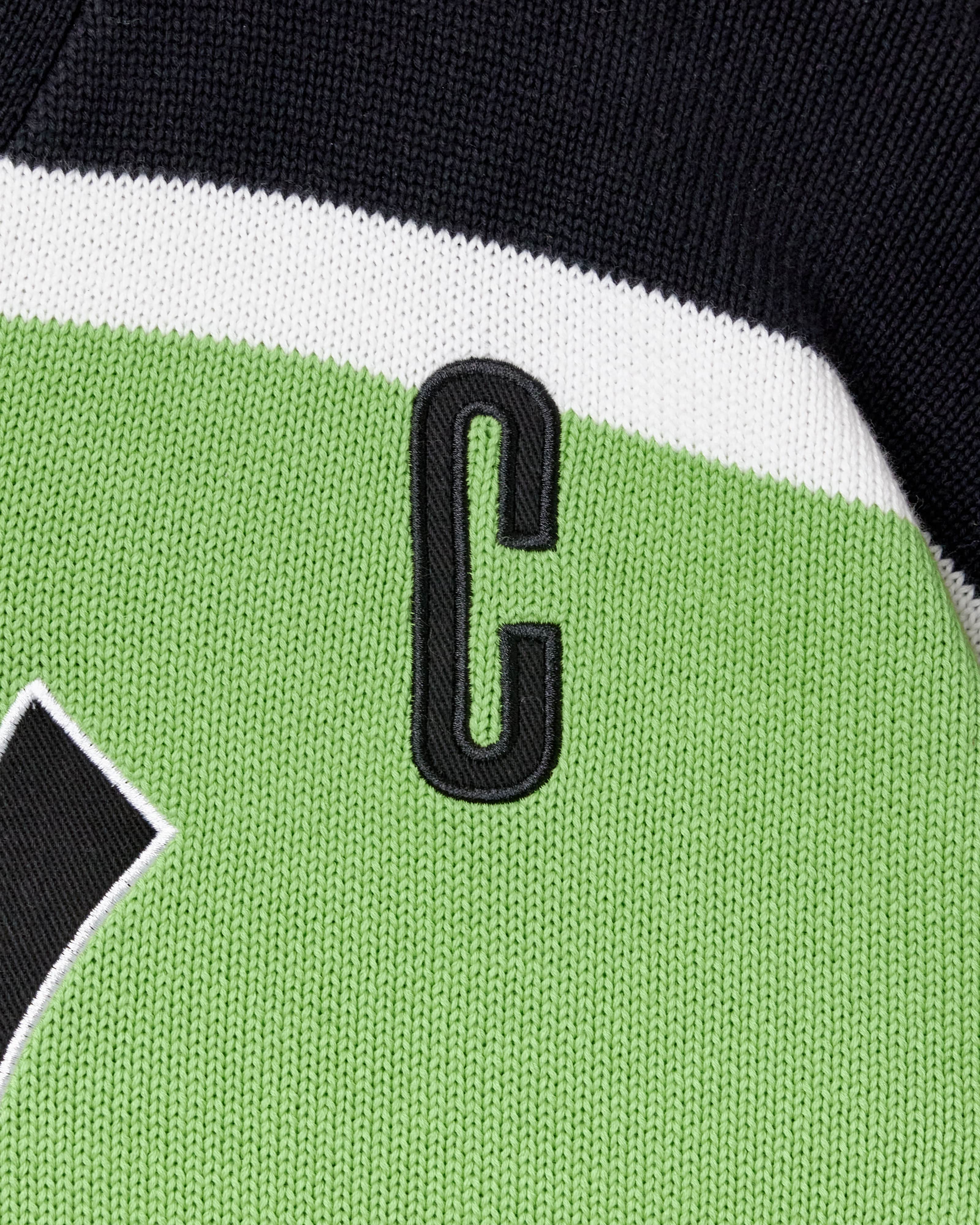 Close-up of a sports jersey with a letter 'C' on a green and black background