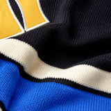 Close-up of a sports jersey with a logo and color-blocked design.