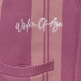 'Wisdom of Age' embroidered on a Pink striped garment. 