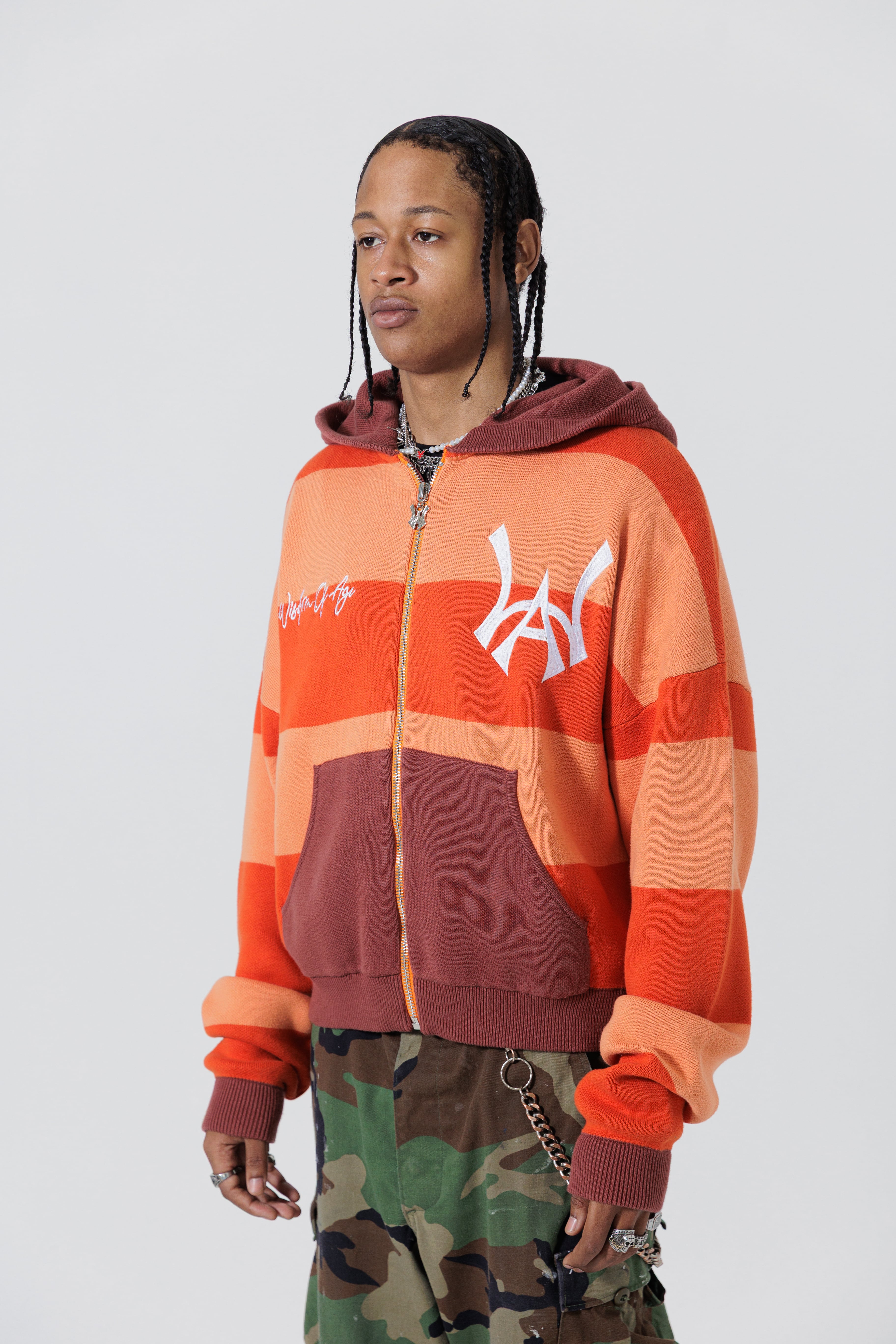 Front Side View Of A Male Model wearing The Wisdom Of Age Knit Hoodie Orange.