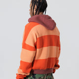 Rear Side View Of A Male Model wearing The Wisdom Of Age Knit Hoodie Orange.
