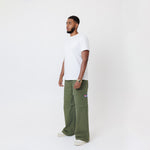 Side view of Male Model wearing a white t-shirt and the WOA Cargos in Olive color on a white background.