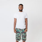 Male Model wearing a white t-shirt and the WOA convertible Cargo shorts in Camo color on a white background.