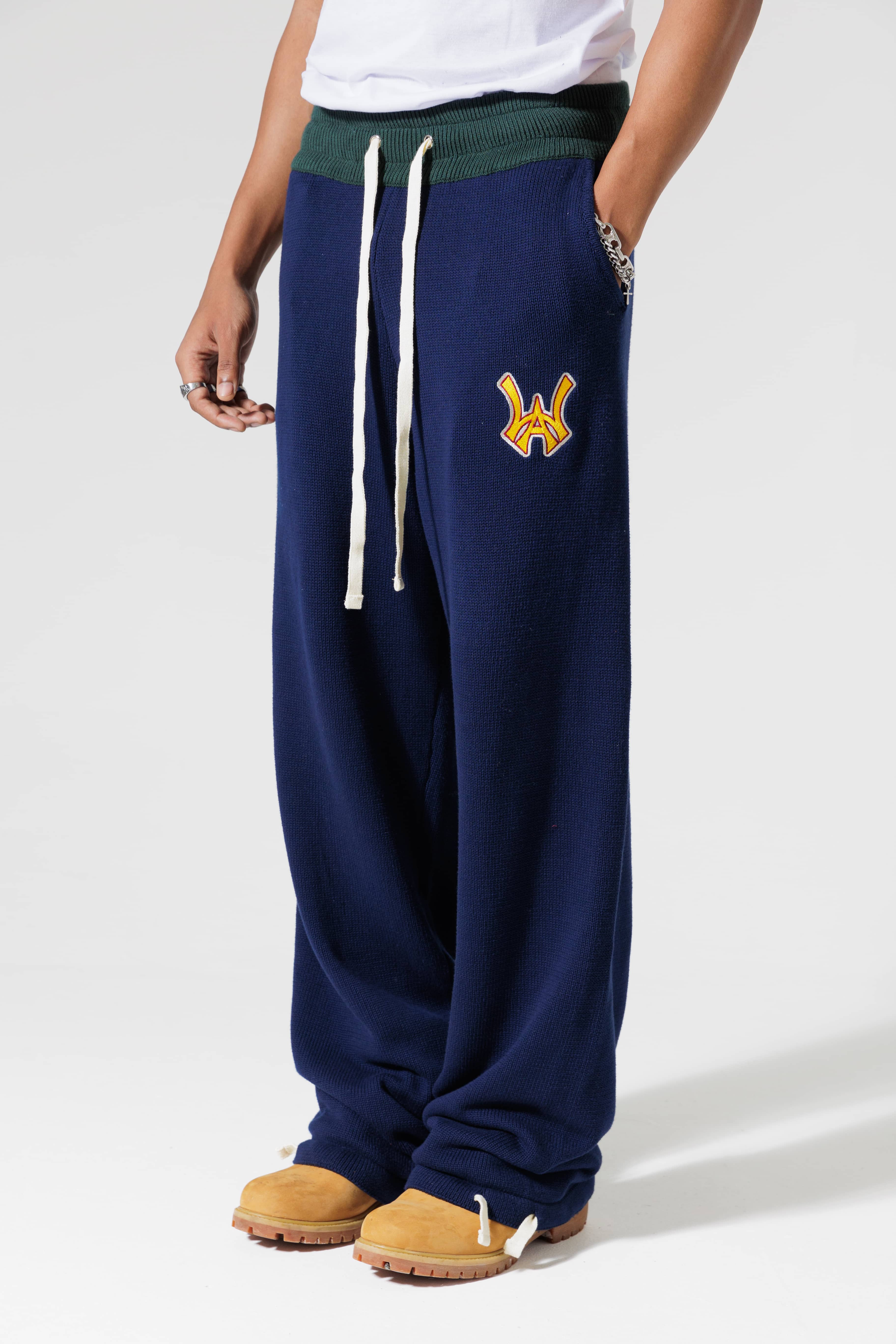 Male Model Wearing The Wisdom Of Age Knit Clinton Sweatpants Navy Front View With his hand in the pocket.