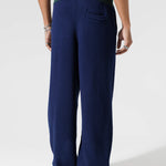 Male Model Wearing The Wisdom Of Age Knit Clinton Sweatpants Navy Rear View.