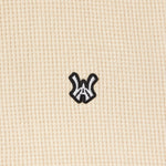 Close up view of the Wisdom Of Age knit thermal shirt in cream. WA Logo embroidered in white with a black outline.