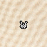 Close up view of the Wisdom Of Age knit thermal shirt in cream. WA Logo embroidered in white with a black outline.