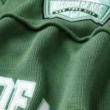 Close-up of a sage green football jersey with 'Wisdom of Age' branding