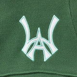 Close-up of a sage green fabric with a white WA logo on a textured background