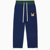 The Wisdom Of Age Knit Clinton Sweatpants Navy Front View. Embroidered Yellow WA logo with a white outline on the left mid-hip. Off-White drawstrings on a dark green waistband
