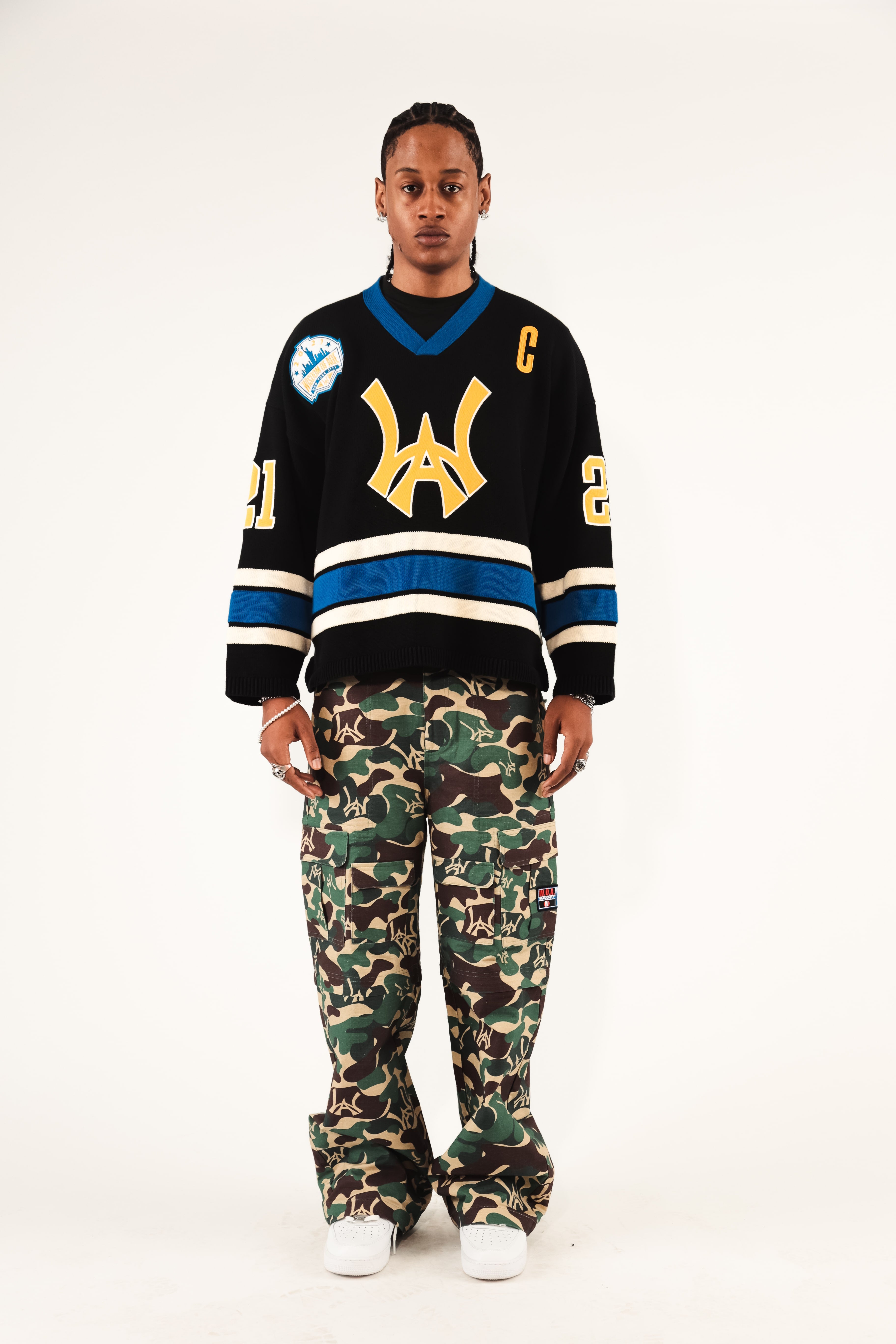 Male Model wearing WOA Hockey Jersey - Static Shock with a yellow WA logo and camouflage pants on a white background