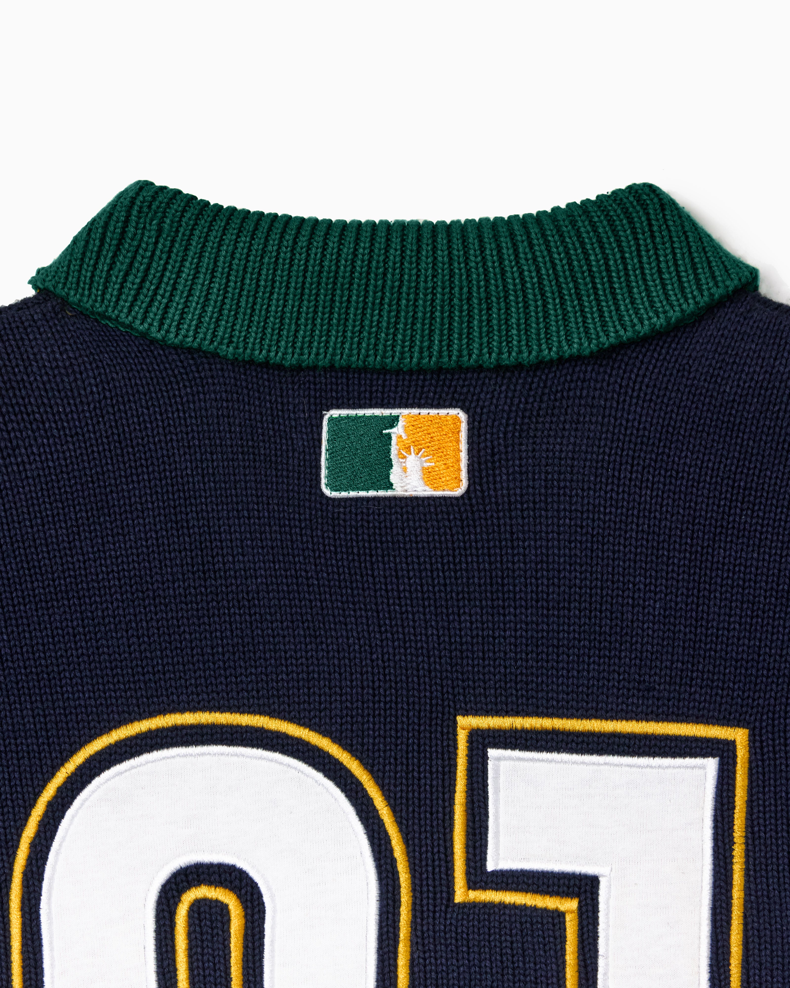 Close up of a green collar with the 'NY tough' logo on a white background.