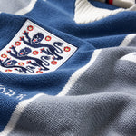 Close-up of a blue and gray sports Wisdom Of Age Knit Soccer jersey Grey Stripe with a prominent emblem.