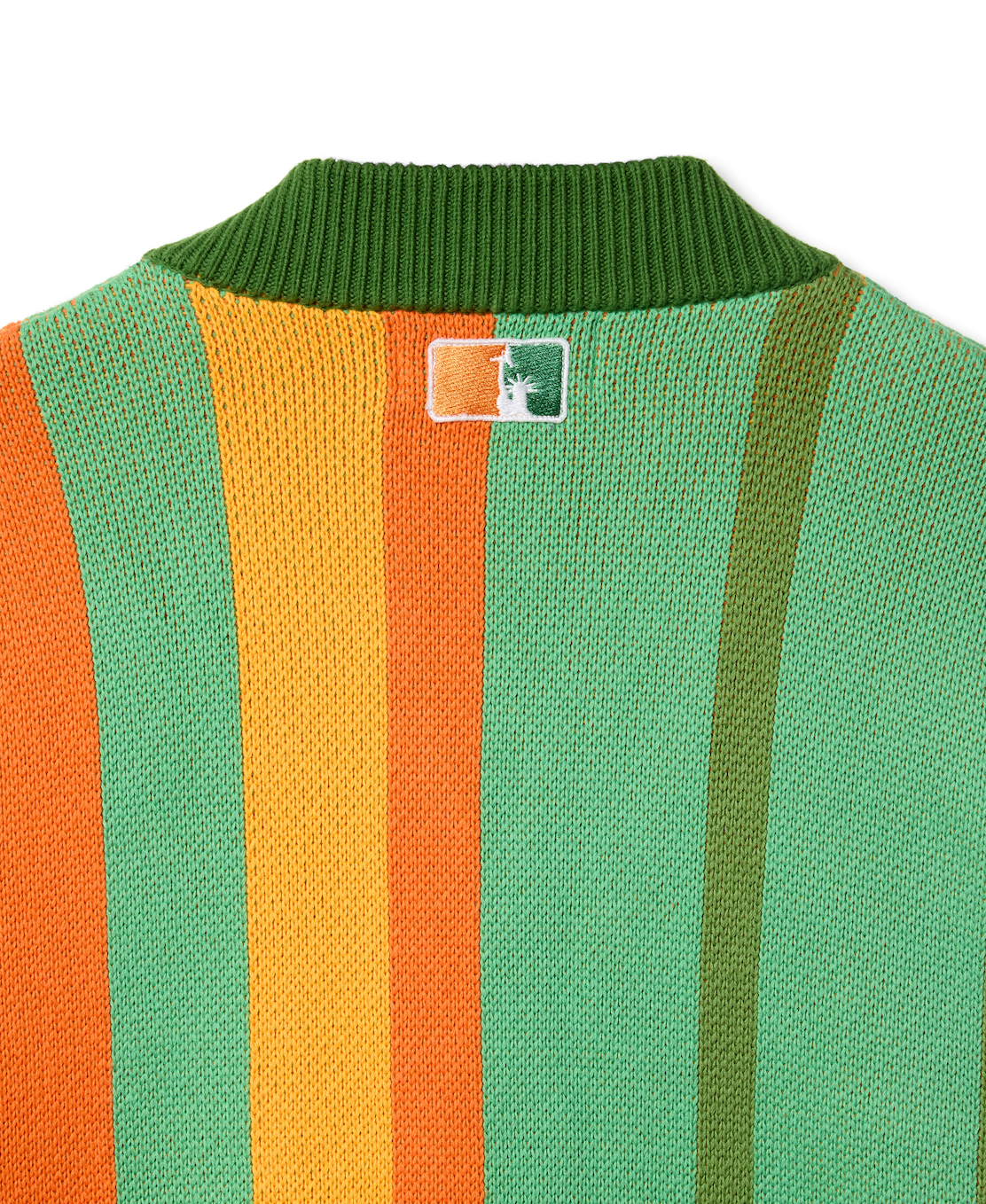 Closer look at the back of the sweater with an embroidered square patch below the nape of the neck and collar. The patch contains the upper half of the Statue of Liberty in a "NY Tough" inspired logo.