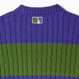 Purple and green cable knit T-shirt with the WOA Liberty logo on a white background