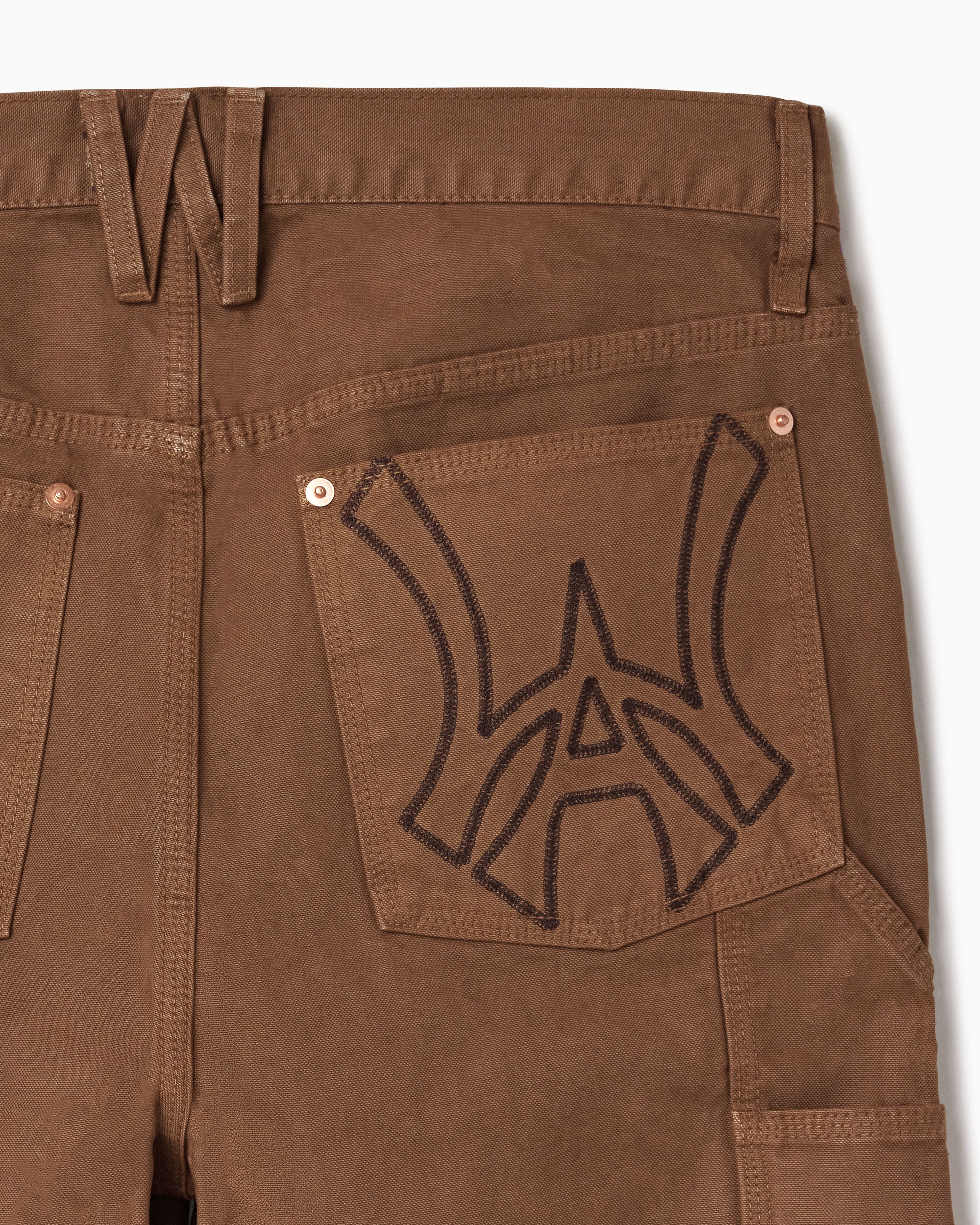 Close up of WOA Canvas Carpenter Shorts in Brick with WA logo on the right back pocket on a white background