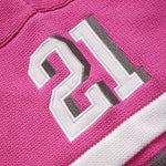 Close-up of the wisdom of age pink knitted football jersey with the number 21 on it.