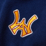 Close Up Of The Wisdom Of Age Knit Clinton Sweatpants Navy Front Logo Patch in Yellow.