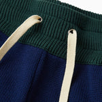 Close up of the waistband of the Wisdom Of Age Knit Sweatpants. Pine green waistband with Cream drawstrings.