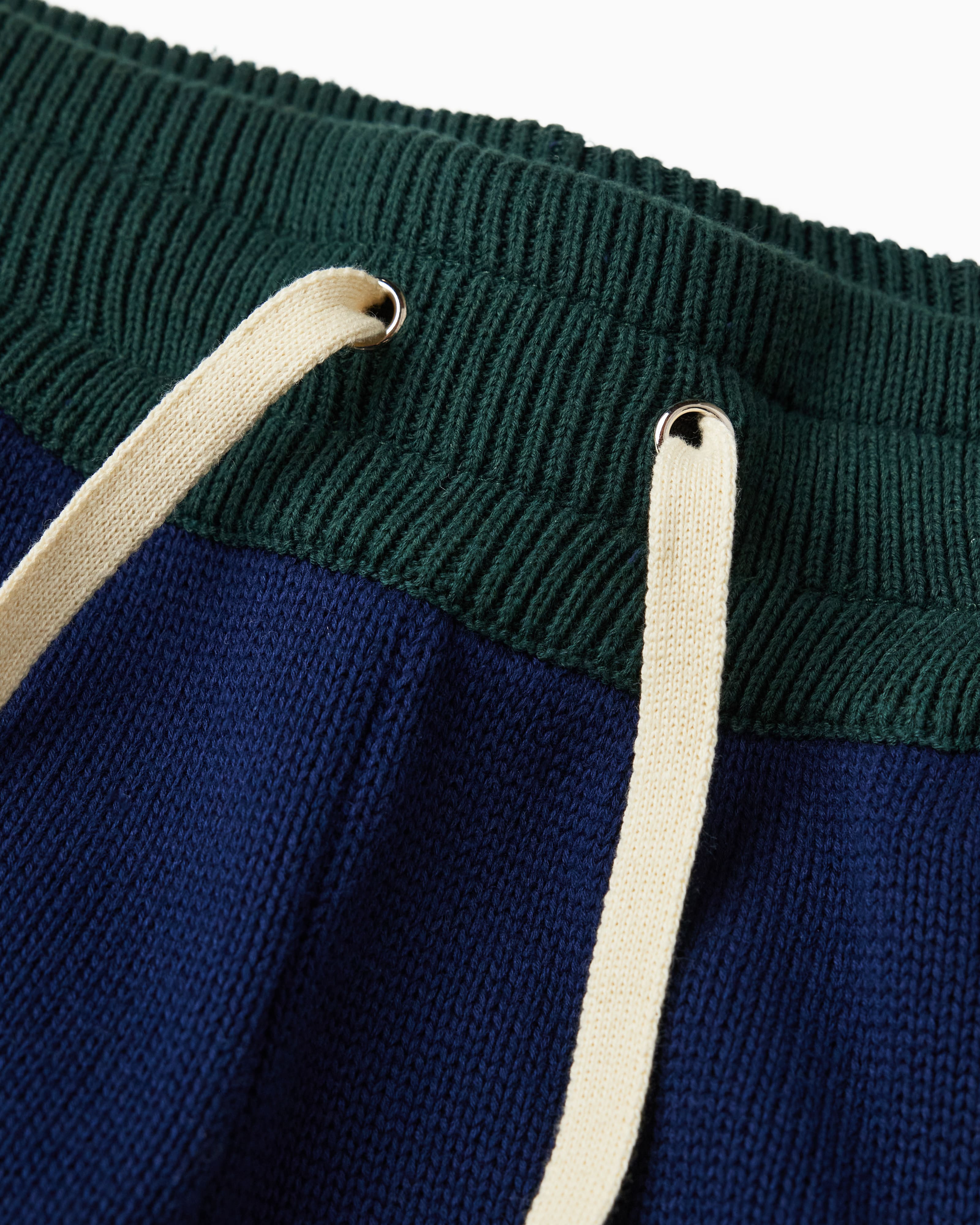 Close up of the waistband of the Wisdom Of Age Knit Sweatpants. Pine green waistband with Cream drawstrings.
