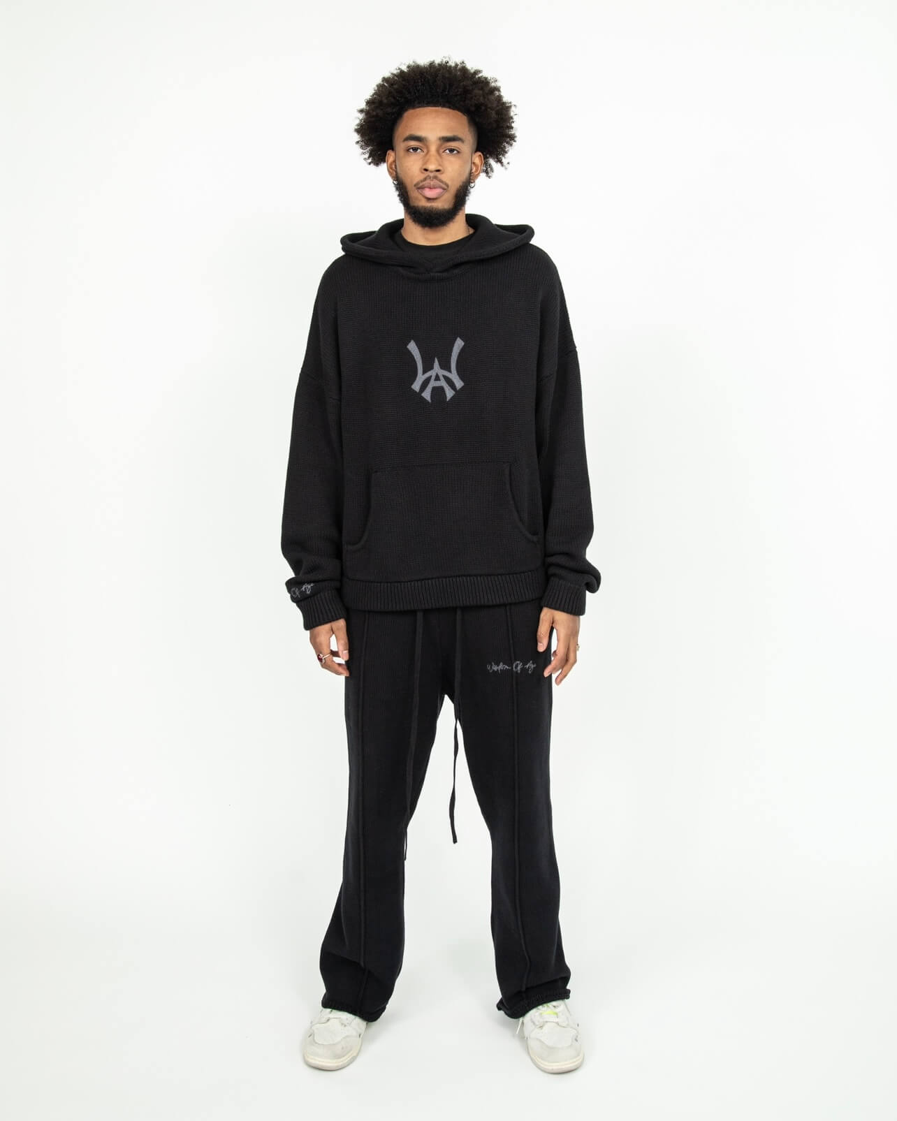 Front head to toe profile of the Knit Hoodie in black. The Hoodie is paired with the Knit Sweatpants in black.