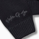 Closer look at the right sleeve with the brand name "Wisdom of Age" embroidered in a handwritten script cursive.