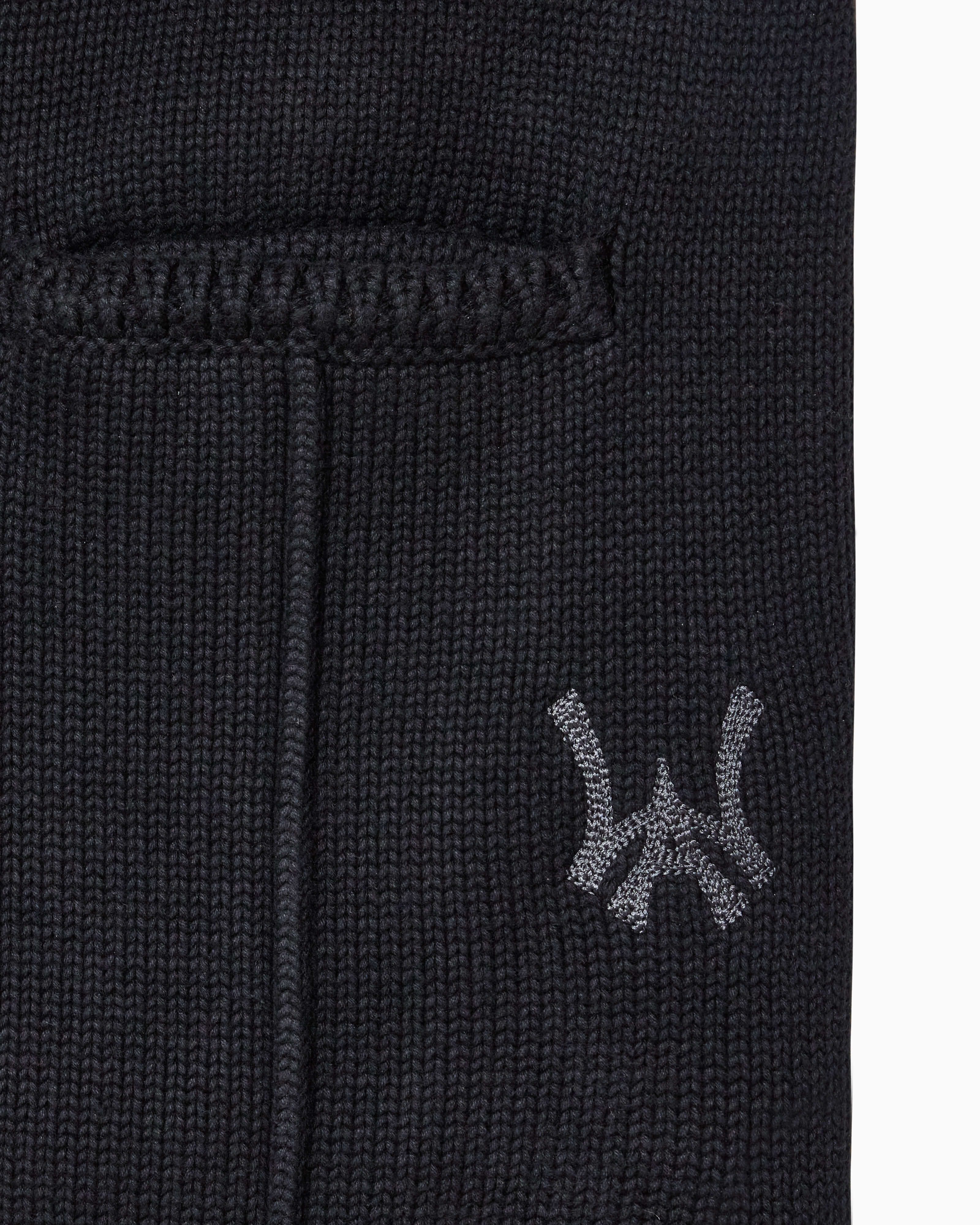 Closer look at the brand logo in a monogram font of connecting the "W" and "A" located below the right back pocket on the right leg.