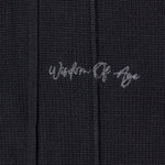 Closer look at the upper left leg with the brand name "Wisdom of Age" embroidered in a handwritten script cursive.