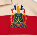 Wisdom of Age Bleecker Rugby Polo in multicolor stripes zoomed front view of embroidered ornate brand emblem .