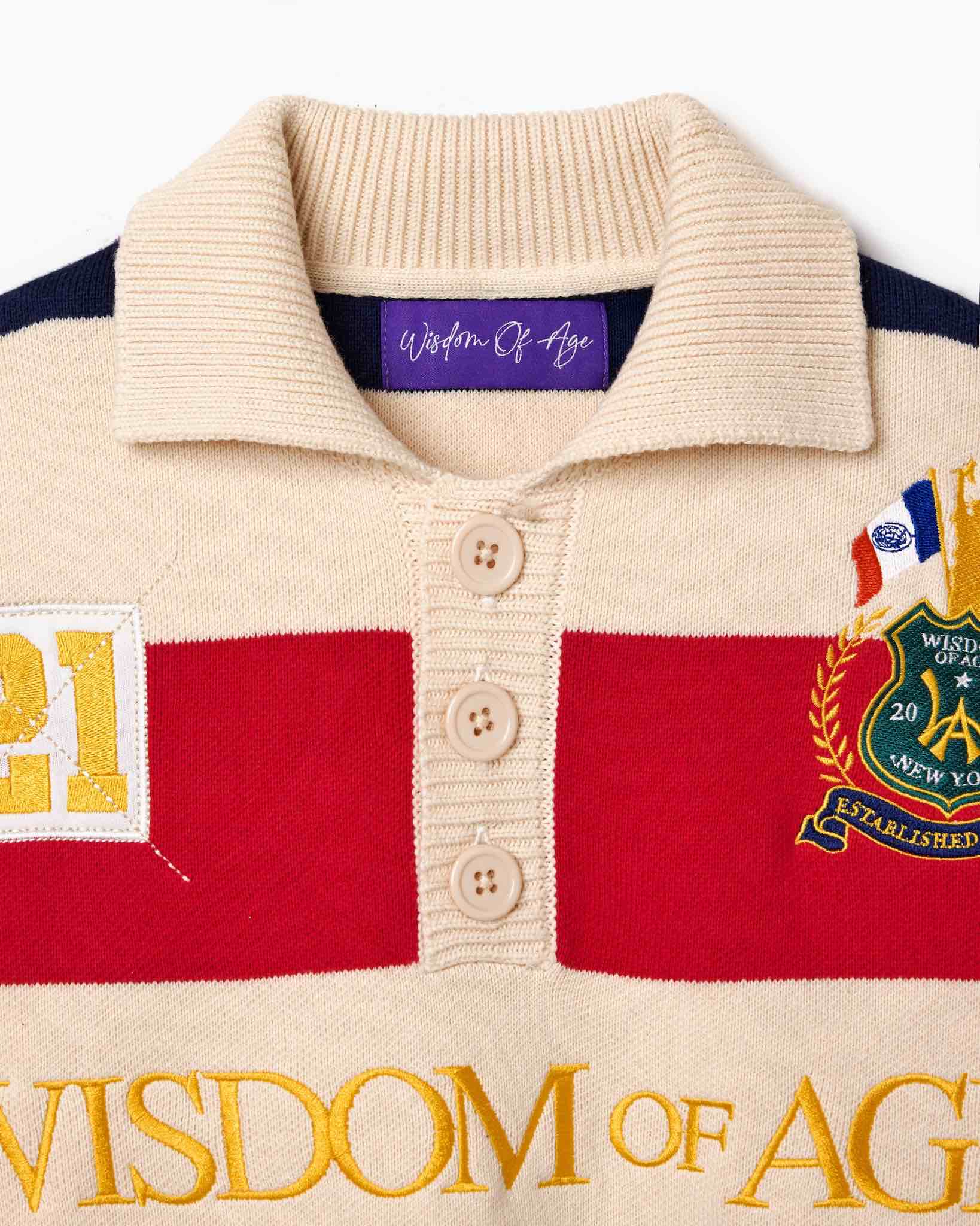 Wisdom of Age Bleecker Rugby Polo in multicolor stripes zoomed front view of collar with three buttons and purple Wisdom of Age inner tag on white background.